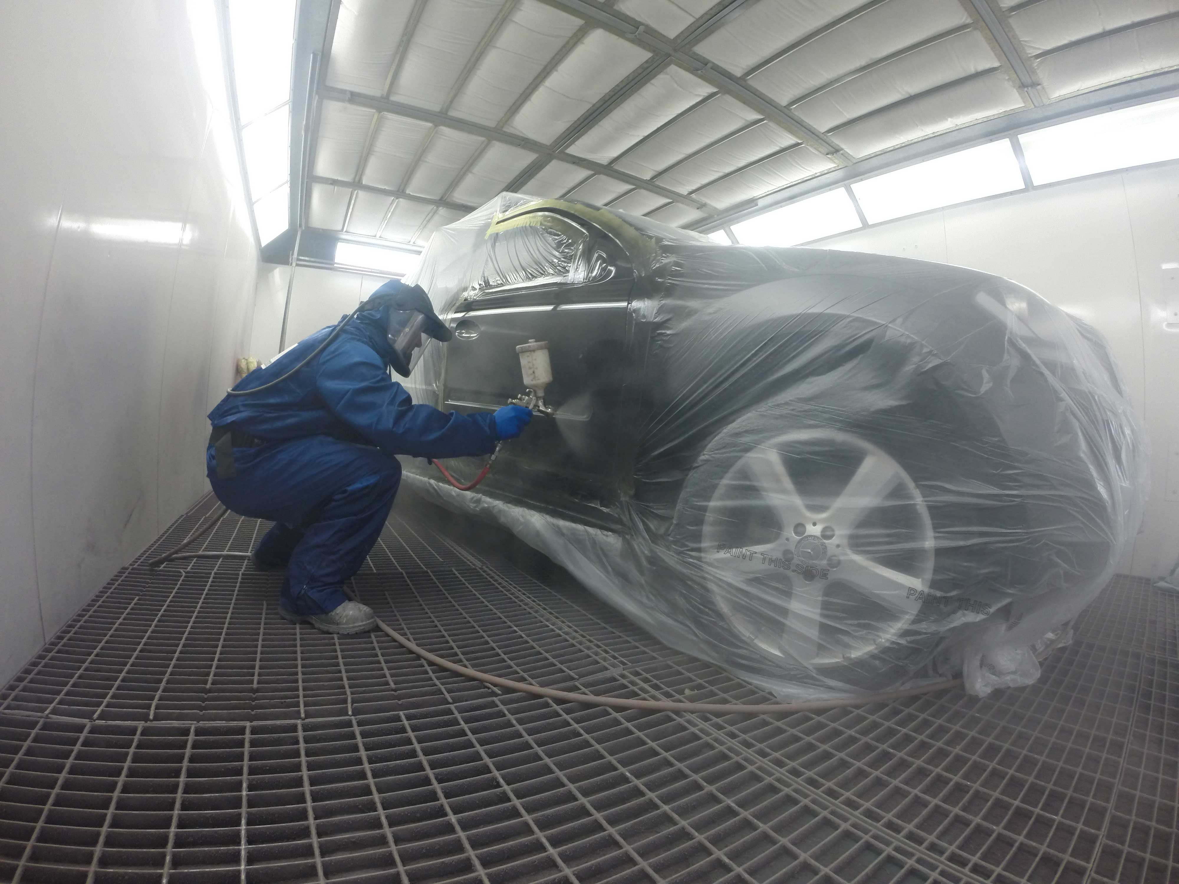 Technician painting an suv